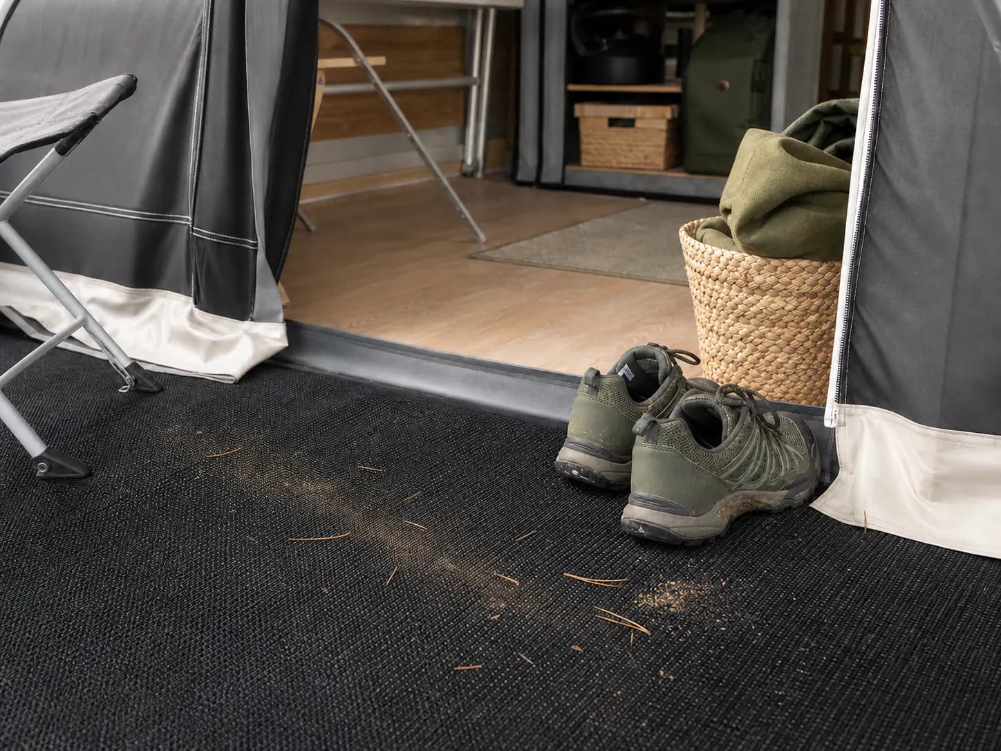 Tørr sand og små barnåler ved inngangen til et fortelt